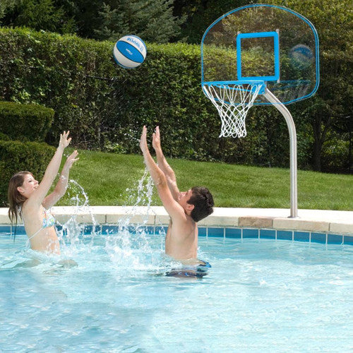 Couple playing basketball in pool with regulation clear hoop mounted on pool deck