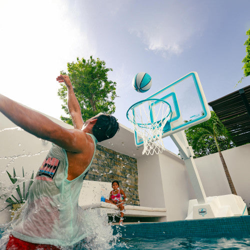 Man playing with adjustable height pool basketball hoop, dunking with waterproof Splash-It ball during summer
