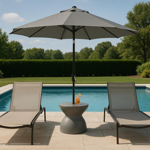 Gray umbrella base set between loungers by inground pool with open umbrella for shade
