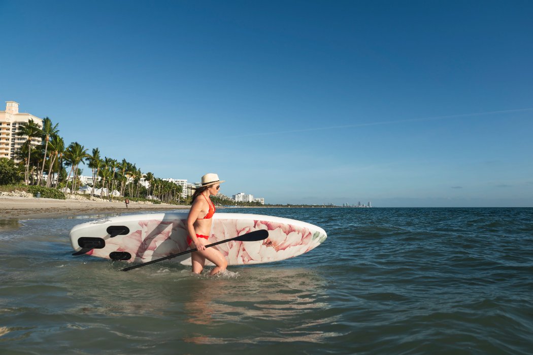 floral inflatable paddleboard - walking in to water