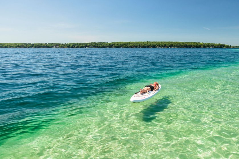 floral inflatable paddleboard - lying down on water